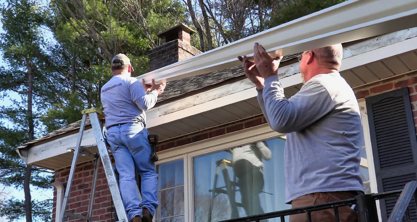 A&A Seamless Gutters crew installing seamless gutters on a brick home